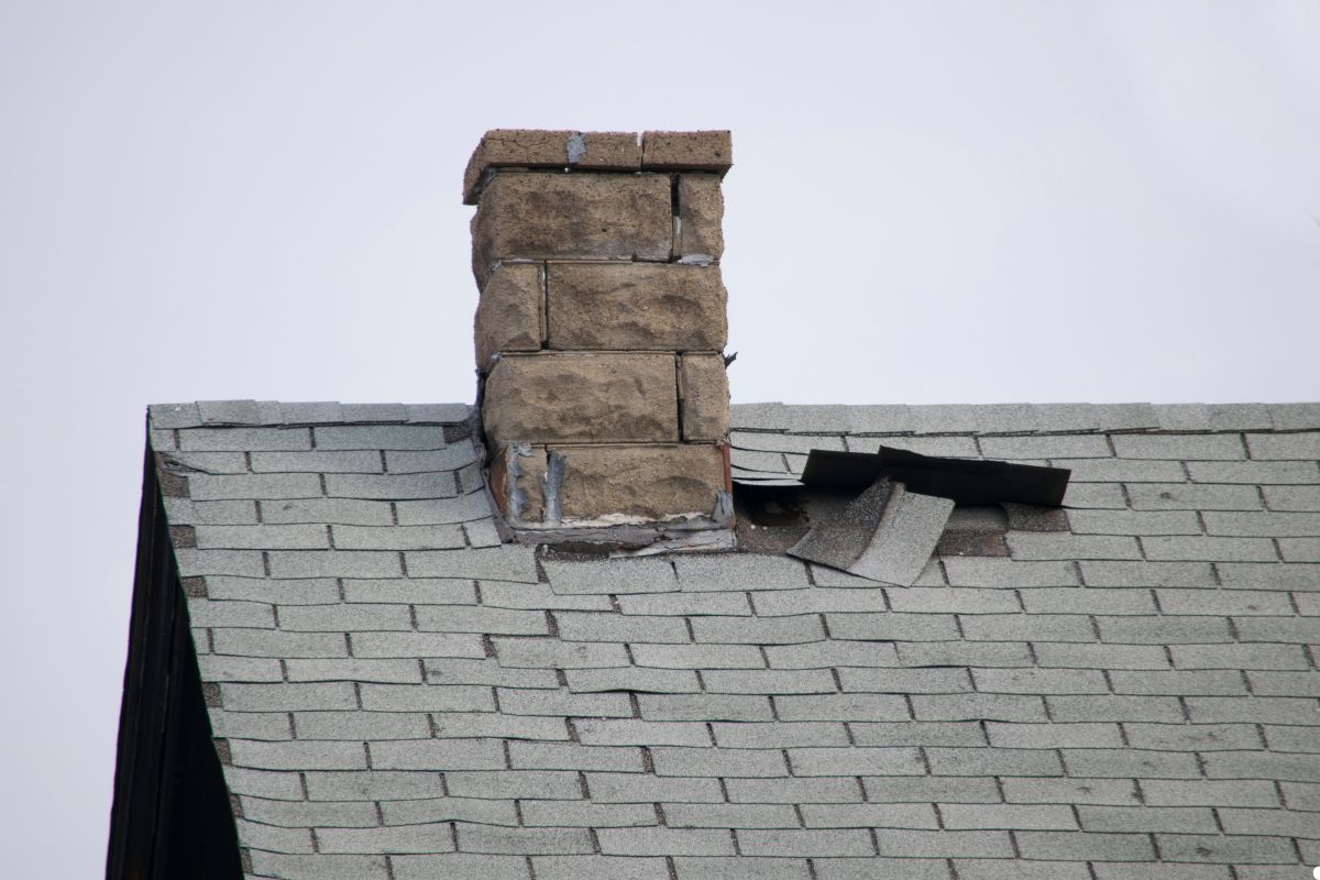 A roof featuring a broken chimney, highlighting the damage and wear on the structure.